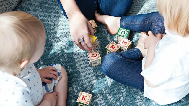 A group engaged in a playful and educational activity, arranging letter cubes to spell words or messages.