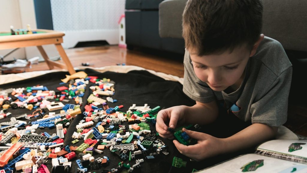 A child engaged in constructive play with colorful Lego bricks, building and creating.